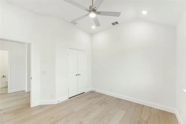 an empty room with a window and ceiling fan