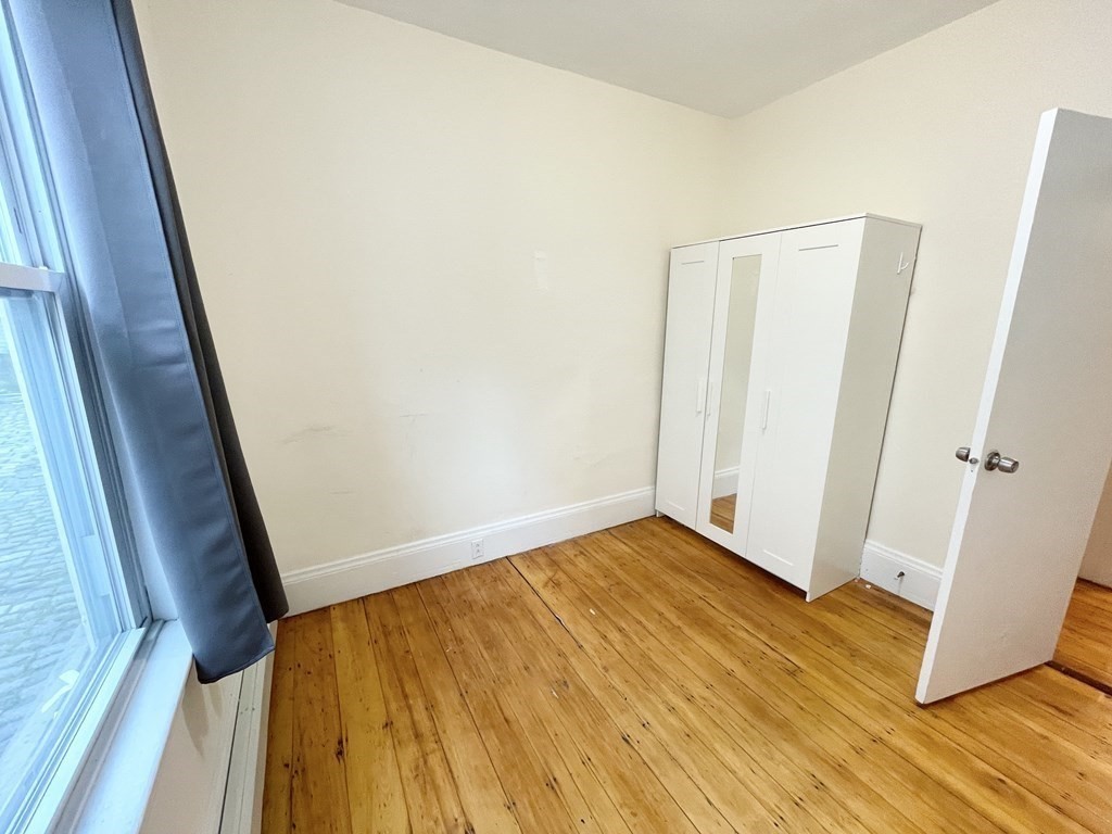 1 Folsom Avenue, Unit 1 Boston, MA 02120 - Photo 5 of 10 a view of an empty room with wooden floor and a window