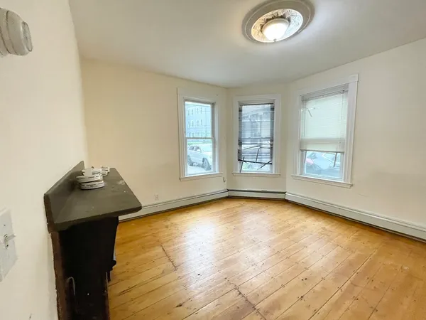 a view of a livingroom with wooden floor and a window