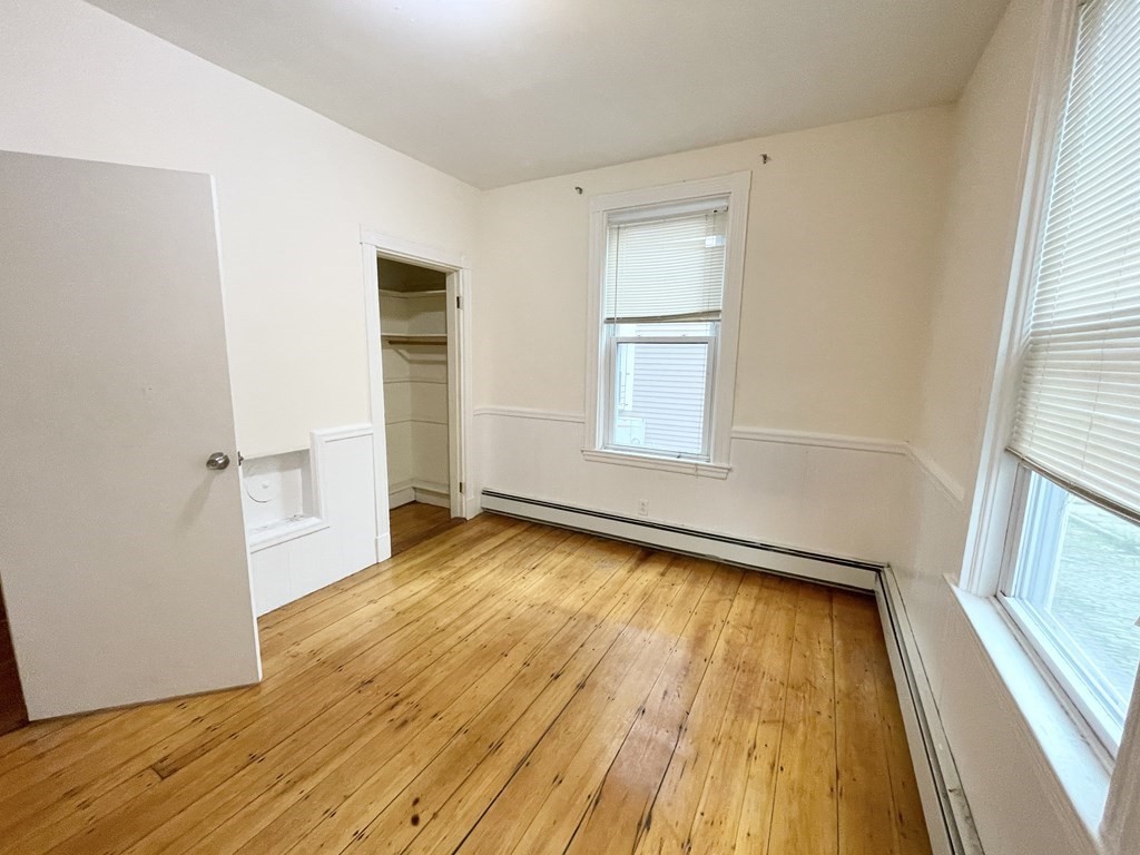 1 Folsom Avenue, Unit 1 Boston, MA 02120 - Photo 8 of 10 an empty room with wooden floor and windows