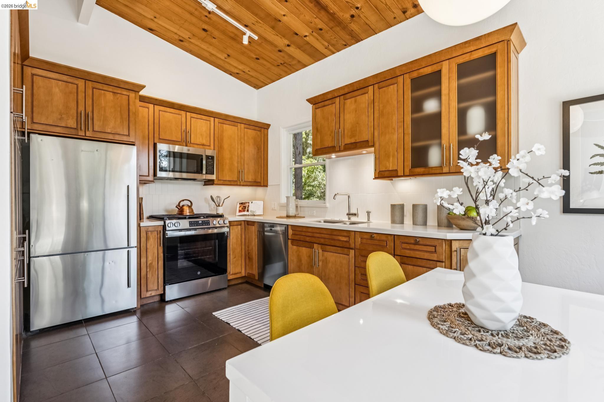 6645 Heather Ridge Way Oakland, CA 94611 - Photo 3 of 61 Kitchen featuring a vaulted wood-finish ceiling, wood cabinetry, stainless steel appliances, white subway tile backsplash, and dark tile flooring