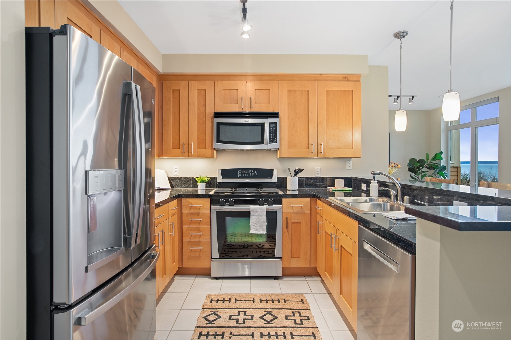 51 Pine Street, Unit 104 Edmonds, WA 98020 - Photo 6 of 40 a kitchen with stainless steel appliances granite countertop a refrigerator stove and sink