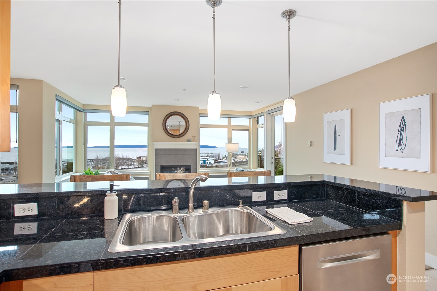51 Pine Street, Unit 104 Edmonds, WA 98020 - Photo 8 of 40 a kitchen with kitchen island granite countertop a sink a stove and a large window with wooden floor