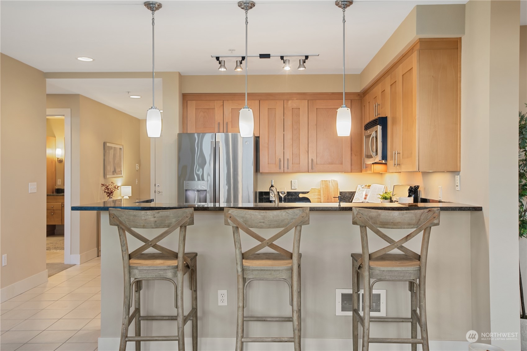 51 Pine Street, Unit 104 Edmonds, WA 98020 - Photo 9 of 40 a kitchen with a table chairs refrigerator and microwave