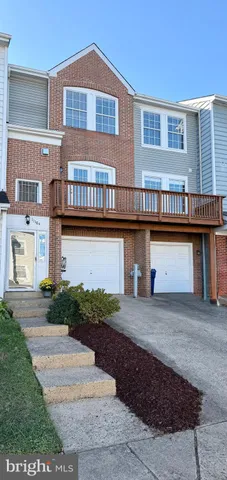 a front view of a house with yard and parking