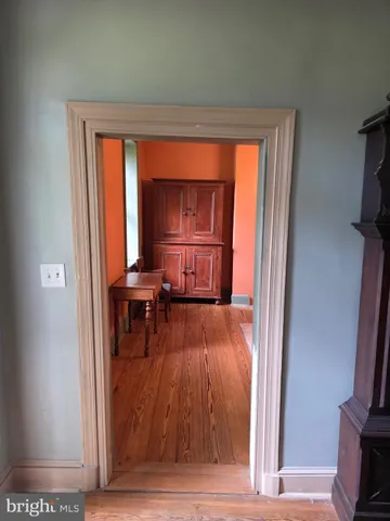 a view of a hallway with wooden floor and furniture