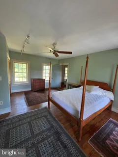 a bedroom with a bed window and dresser