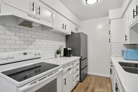 a kitchen with a stove cabinets and wooden floor