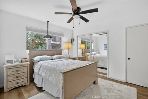 a bedroom with a bed a dresser and a chandelier