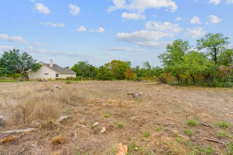a view of a dry yard with trees