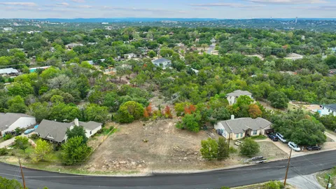 an aerial view of residential houses with outdoor space and trees