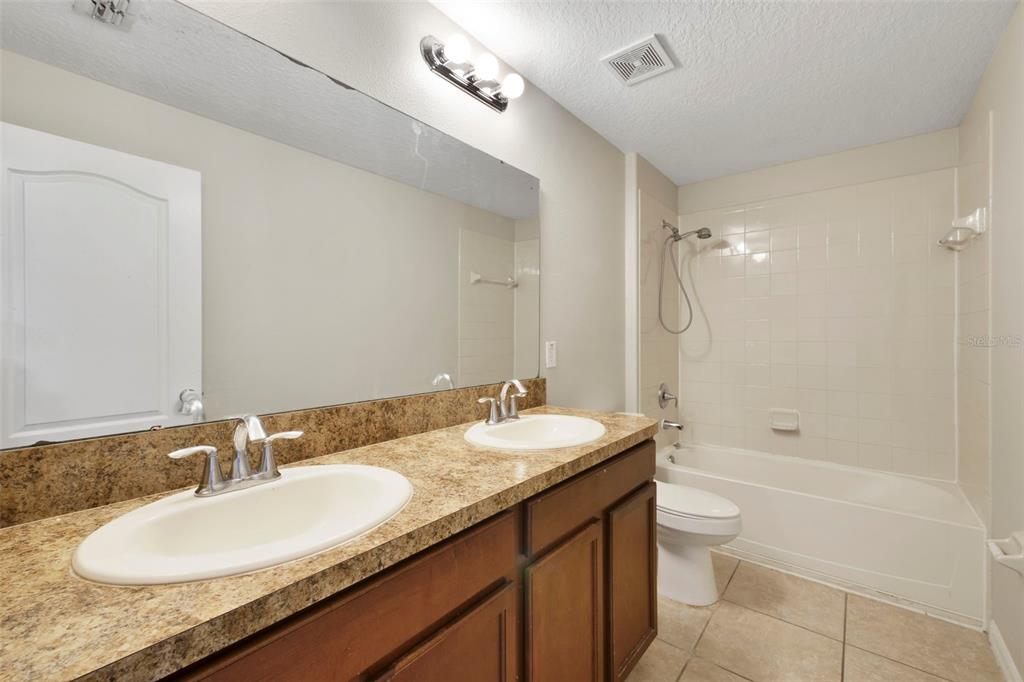 1209 Seburn Road Apopka, FL 32703 - Photo 11 of 25 a bathroom with a granite countertop double vanity sink a mirror and a bathtub