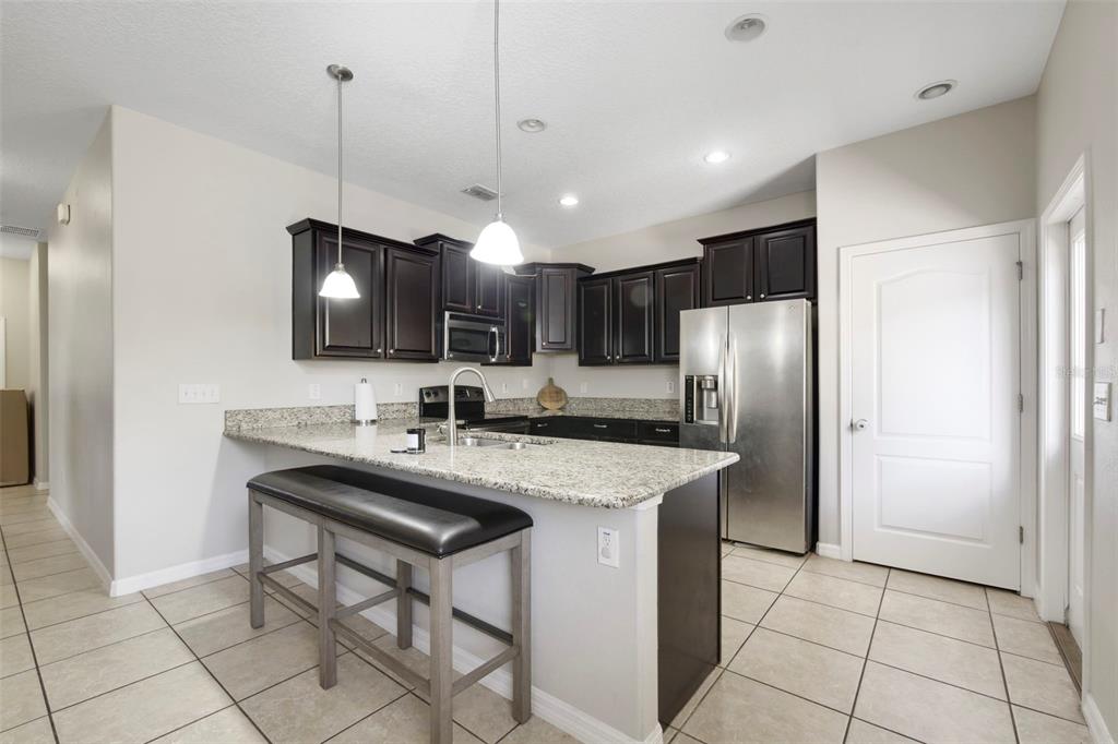 1209 Seburn Road Apopka, FL 32703 - Photo 6 of 25 a kitchen with stainless steel appliances granite countertop a sink a stove a refrigerator and island with wooden floor