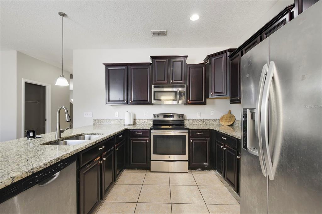 1209 Seburn Road Apopka, FL 32703 - Photo 7 of 25 a kitchen with stainless steel appliances granite countertop a sink stove and refrigerator