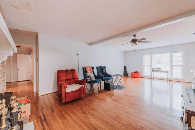 a living room with furniture and a flat screen tv with kitchen view