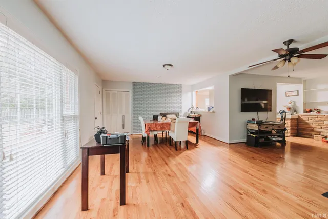 a dining room with wooden floor and window