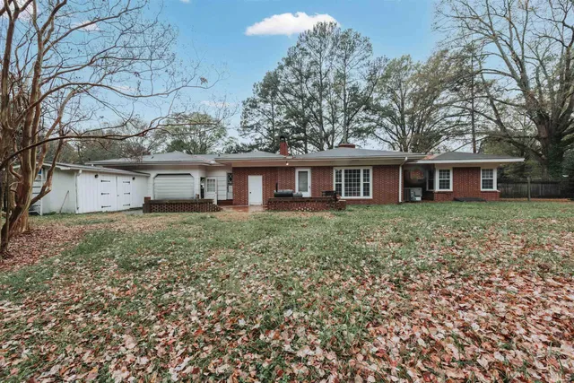 a view of a house with a yard and sitting area