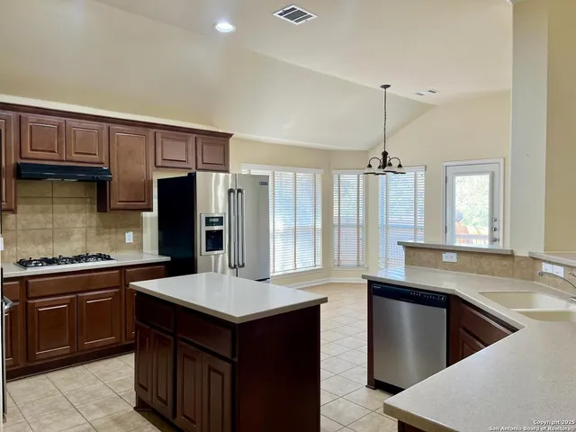 a kitchen with a sink a stove and wooden floor