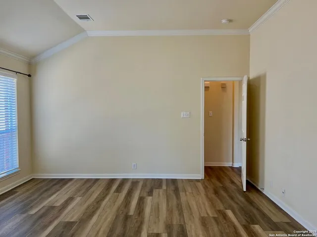 a view of a room with wooden floor and a window