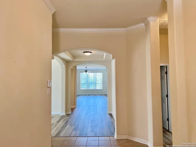 an empty room with wooden floor a fireplace and windows