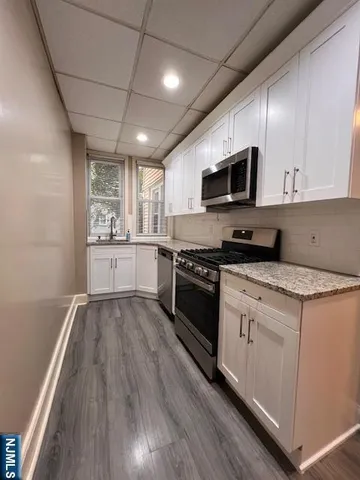 a kitchen with stainless steel appliances kitchen island granite countertop a stove a sink and a microwave