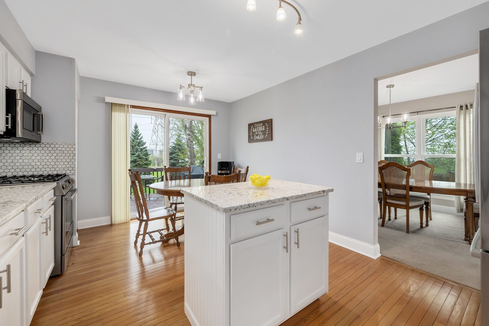 772 Rebecca Lane Bolingbrook, IL 60440 - Photo 9 of 27 a kitchen with a stove a sink a dining table and chairs
