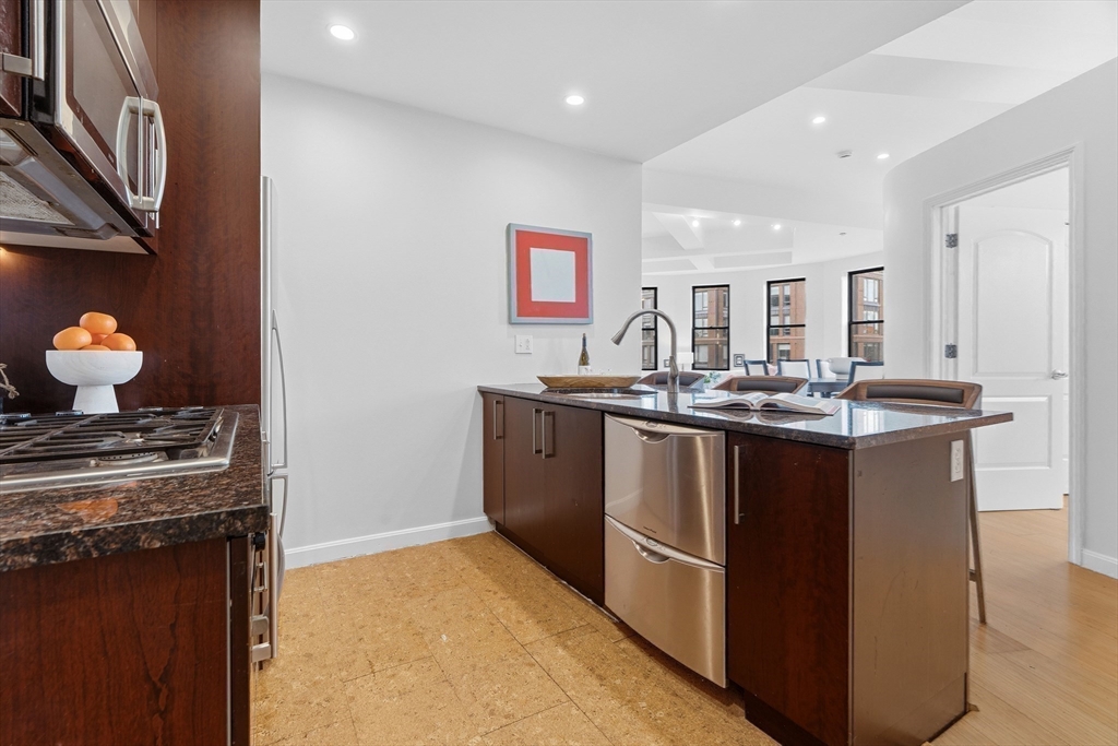 40 Fay Street, Unit 406 Boston, MA 02118 - Photo 7 of 19 a kitchen with kitchen island granite countertop a sink cabinets and stainless steel appliances