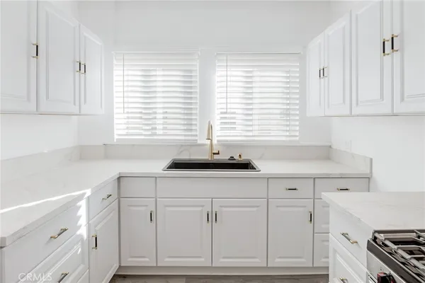 a kitchen with white cabinets and a sink