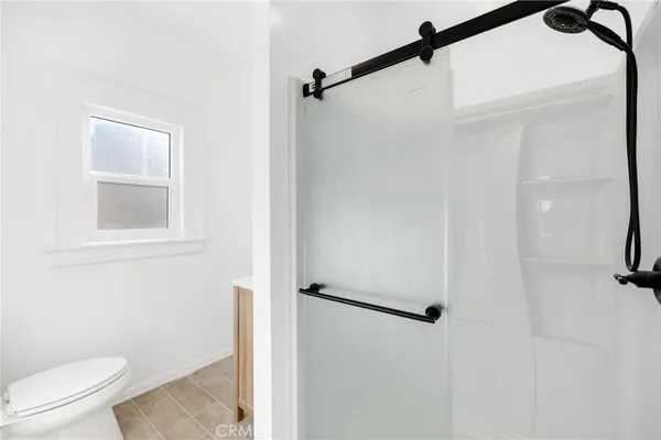 a bathroom with a toilet and a shower