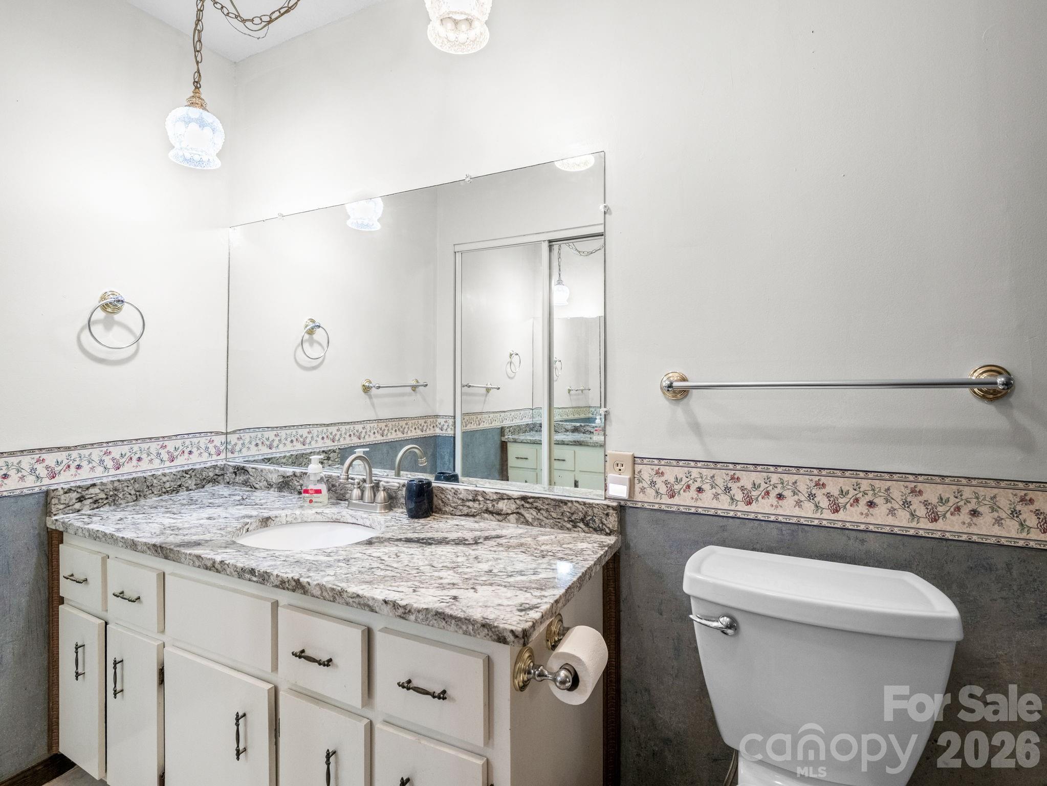 111 Buckeye Road Lake Lure, NC 28746 - Photo 13 of 48 a bathroom with a granite countertop sink a mirror and a toilet