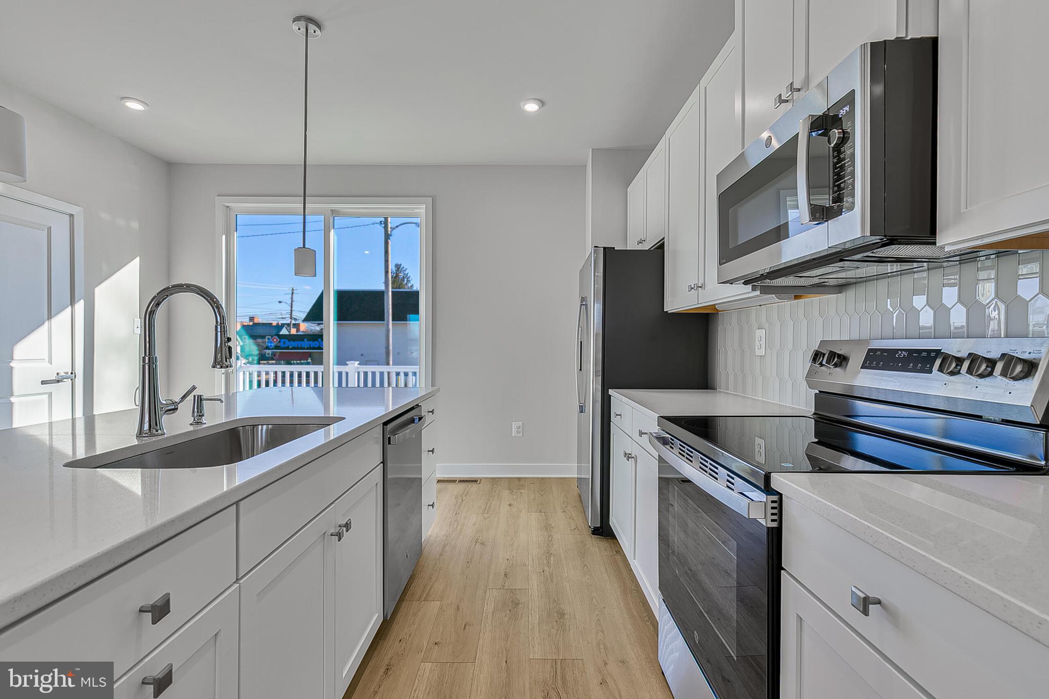 64 F Oasis Avenue Ranson, WV 25438 - Photo 13 of 39 a kitchen with stainless steel appliances granite countertop a sink a stove and a wooden floors