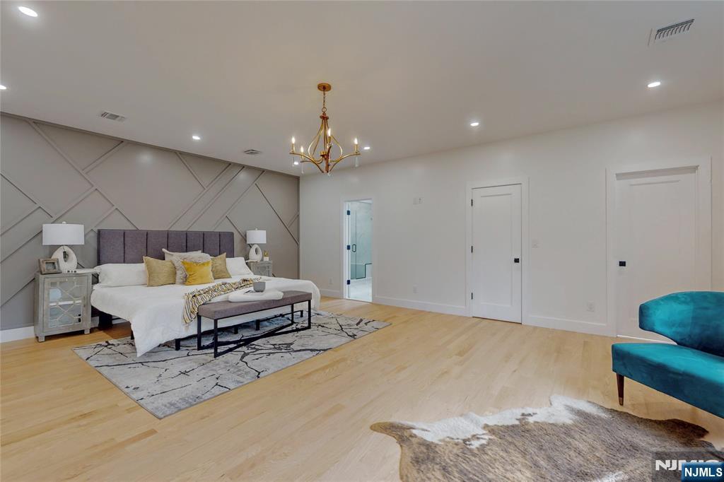 415 Bailey Road Paramus, NJ 07652 - Photo 25 of 44 a spacious bedroom with a bed a couch and chandelier