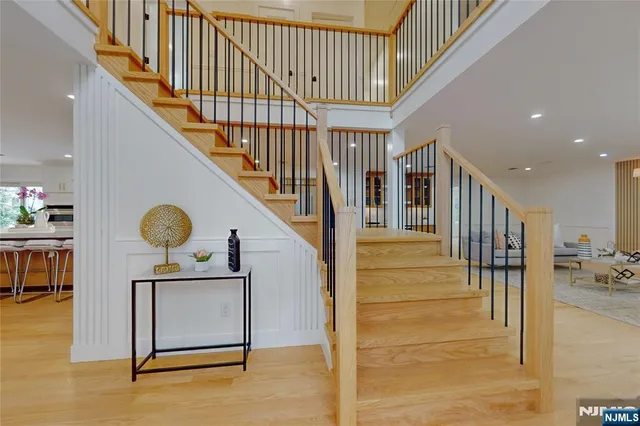 a kitchen with stainless steel appliances granite countertop a kitchen island a stove a refrigerator a sink a dining table and chairs with wooden floor