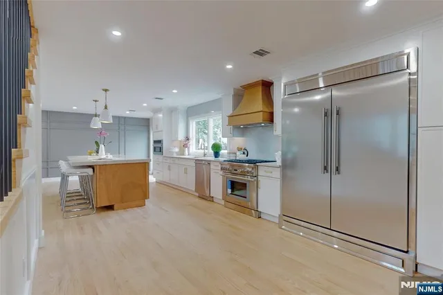 a kitchen with stainless steel appliances granite countertop a stove a sink and a refrigerator