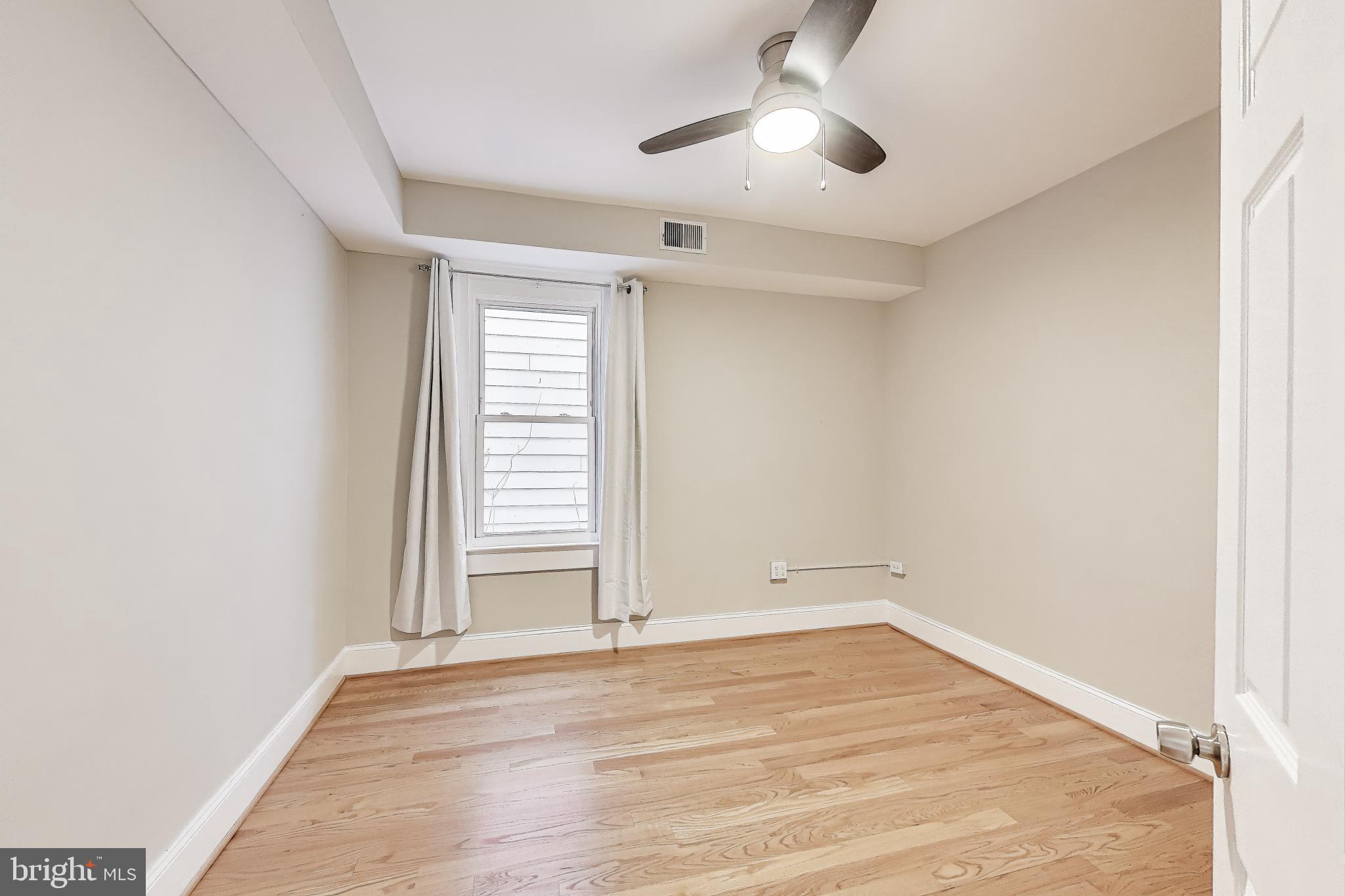 212 Elm Street Northwest Washington, DC 20001 - Photo 14 of 50 an empty room with wooden floor and windows