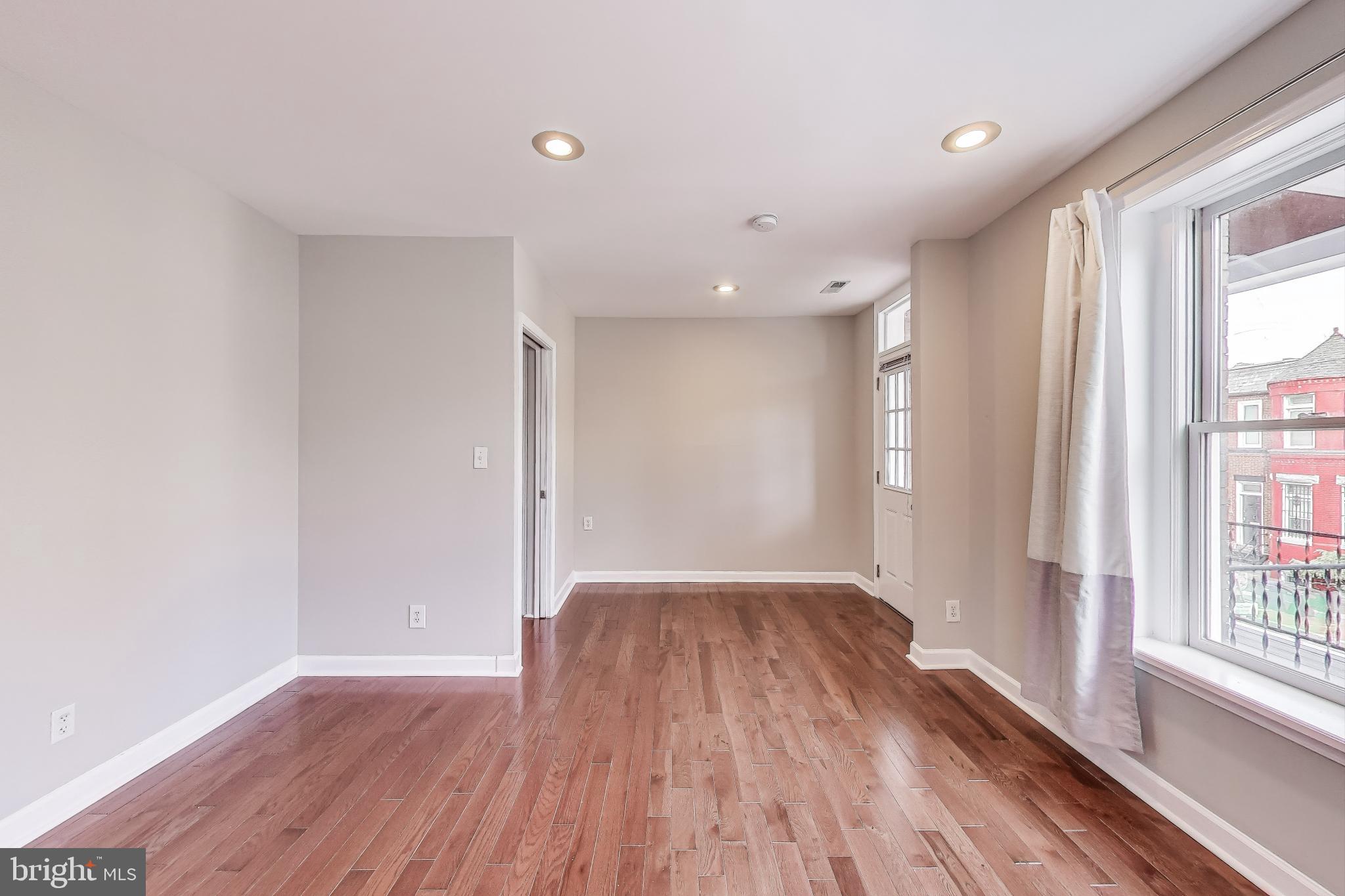 212 Elm Street Northwest Washington, DC 20001 - Photo 23 of 50 a view of an empty room with wooden floor and a window