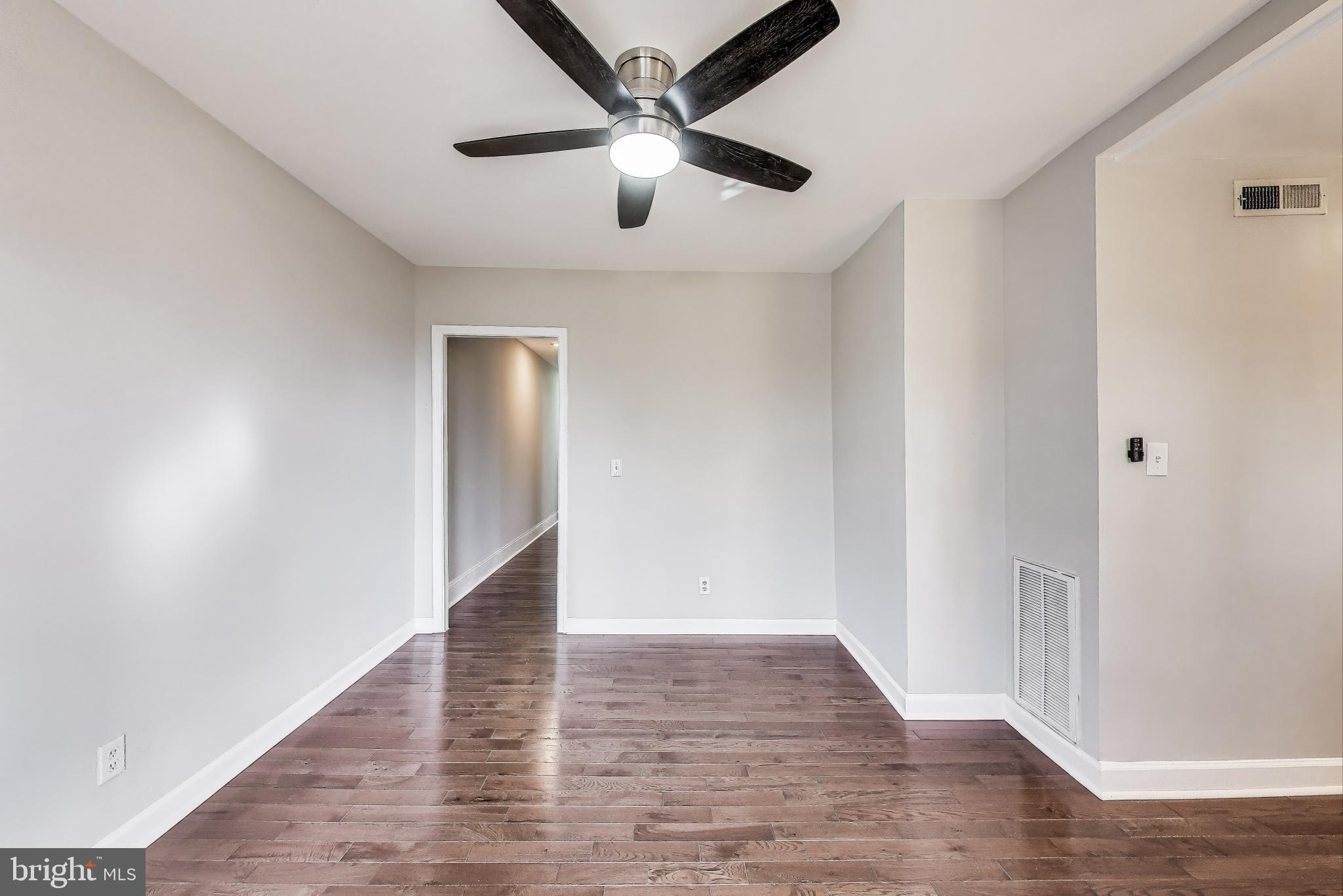 212 Elm Street Northwest Washington, DC 20001 - Photo 30 of 50 an empty room with wooden floor and a ceiling fan