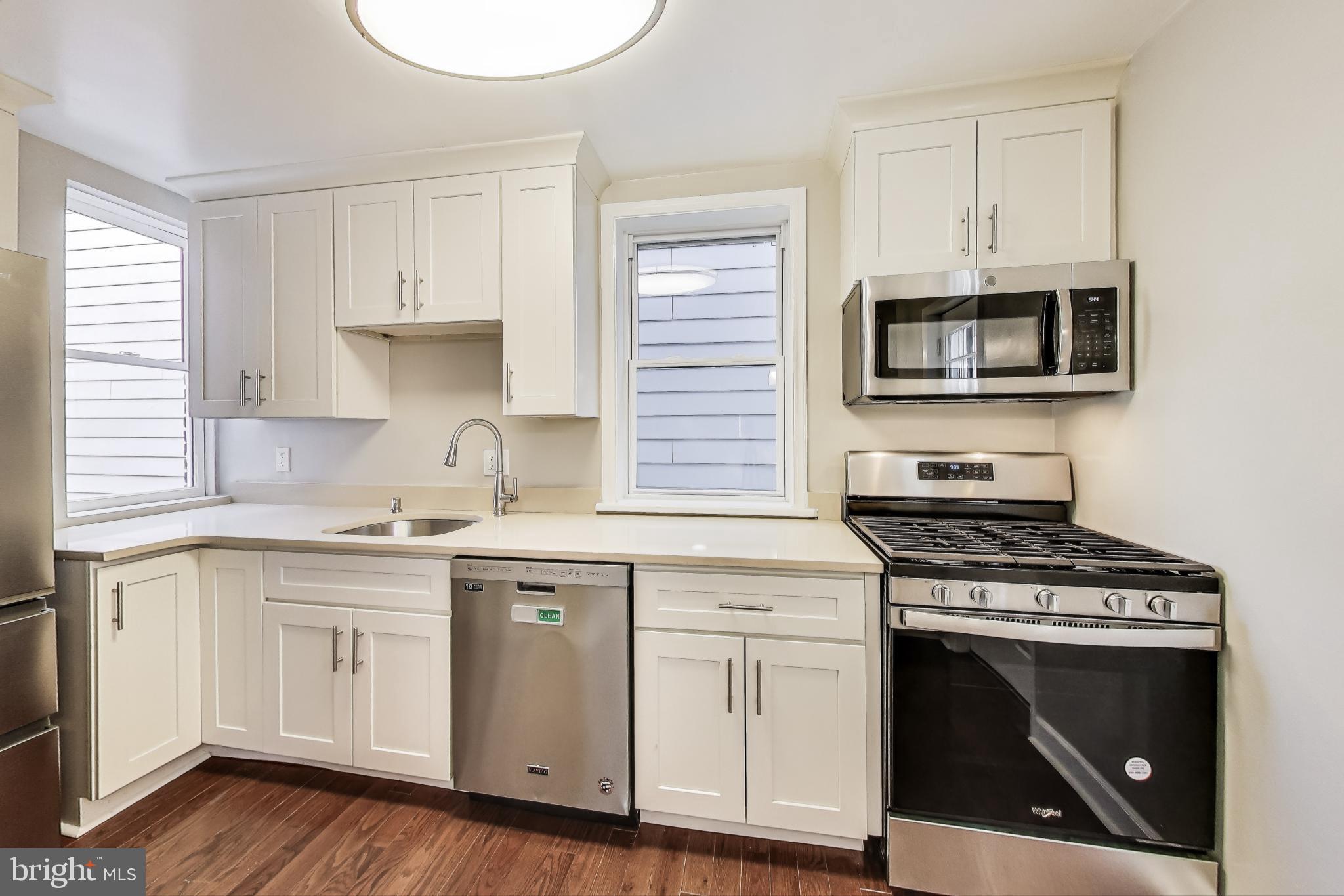 212 Elm Street Northwest Washington, DC 20001 - Photo 31 of 50 a kitchen with cabinets stainless steel appliances and a sink