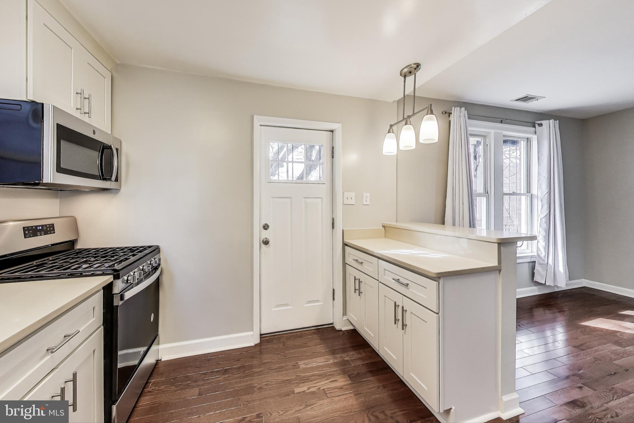 212 Elm Street Northwest Washington, DC 20001 - Photo 33 of 50 a kitchen with stainless steel appliances granite countertop a stove a sink and a microwave