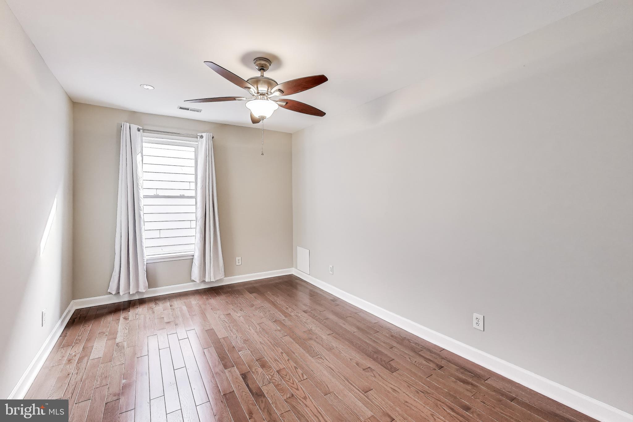 212 Elm Street Northwest Washington, DC 20001 - Photo 34 of 50 a view of an empty room with wooden floor and a window