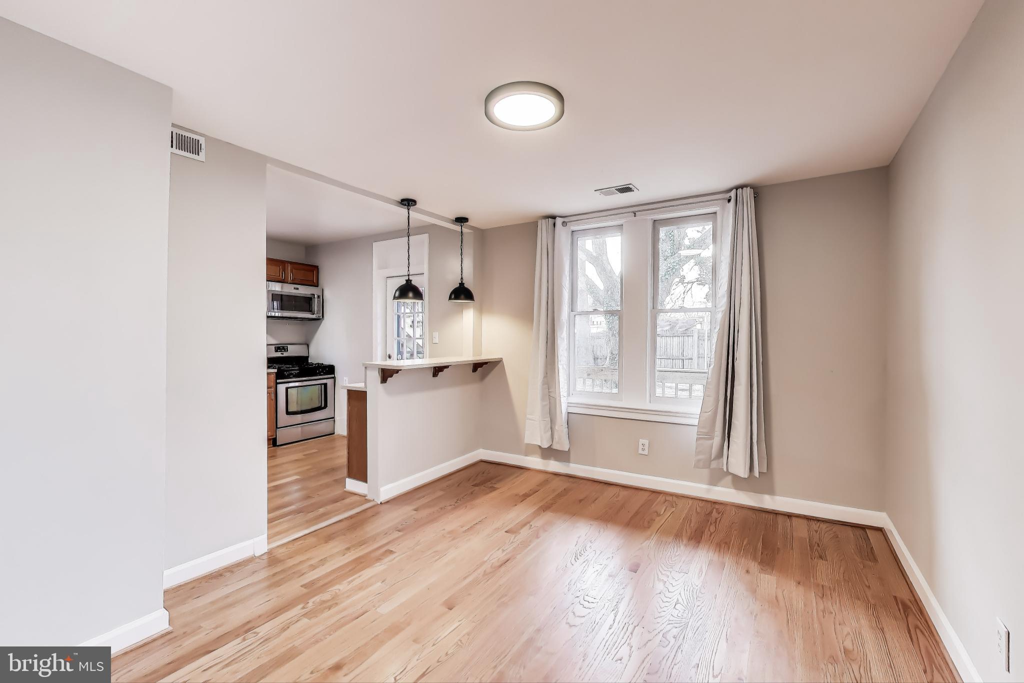 212 Elm Street Northwest Washington, DC 20001 - Photo 6 of 50 a kitchen with white cabinets and wooden floor