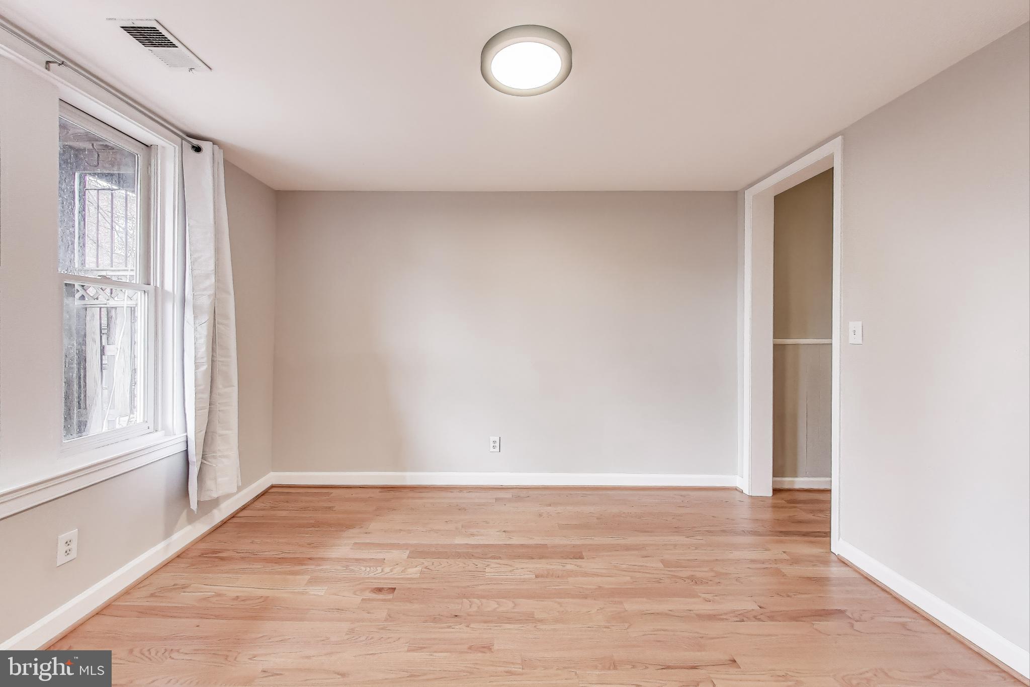 212 Elm Street Northwest Washington, DC 20001 - Photo 7 of 50 a view of empty room with wooden floor and fan