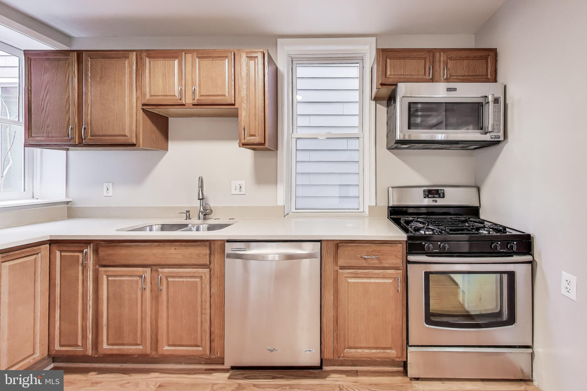 212 Elm Street Northwest Washington, DC 20001 - Photo 10 of 50 a kitchen with granite countertop a stove top oven microwave and cabinets