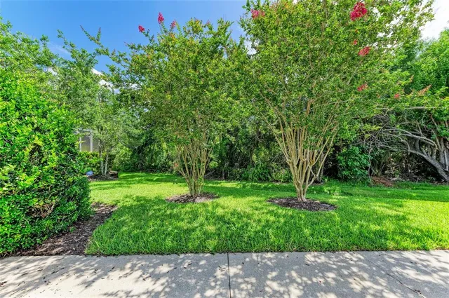 a front view of a house with a garden and trees