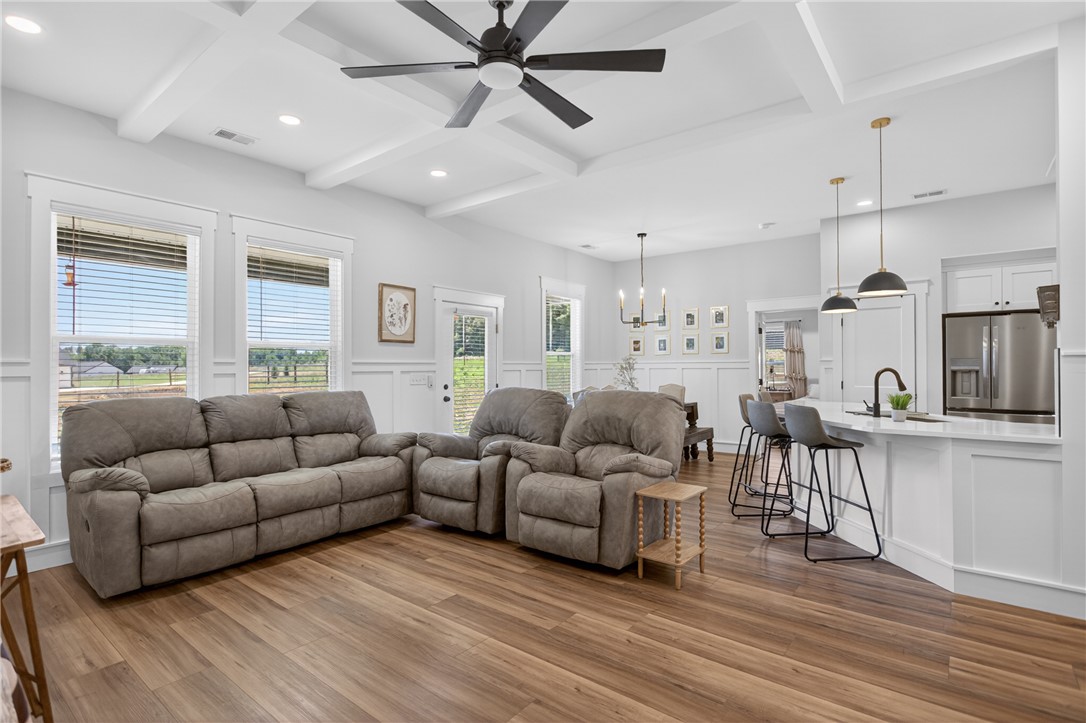 106 Bolt Road Townville, SC 29689 - Photo 4 of 33 An open concept living area boasts elegant tray ceilings and rich wood flooring, connecting seamlessly to a modern kitchen with a large island.