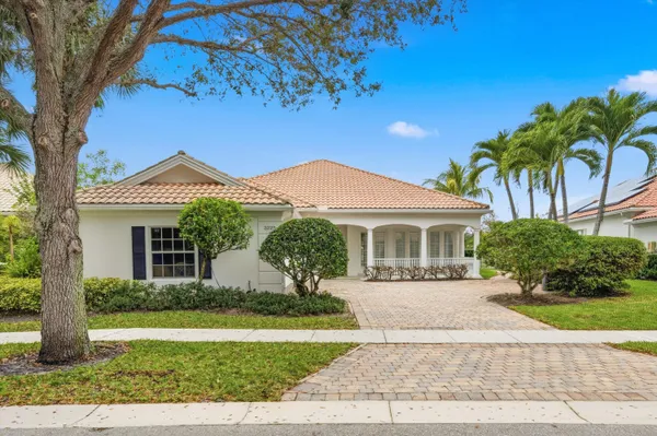 a front view of a house with a yard and potted plants