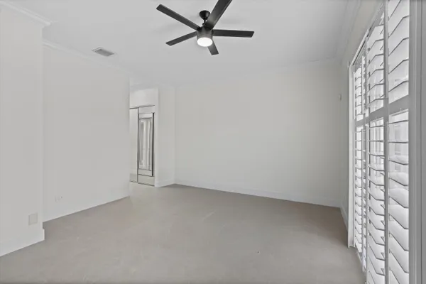 an empty room with a window and a fan