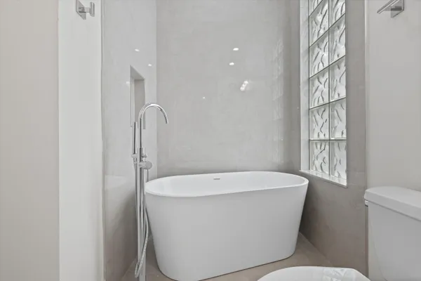 a white bath tub sitting next to a white toilet