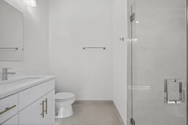 a bathroom with a granite countertop toilet a sink and a shower