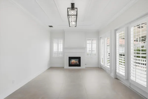 an empty room with windows and fireplace